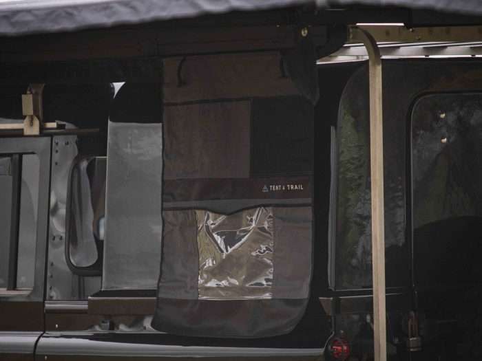 Multi pocket storage caddy hanging from a kador strip under 270 awning on a Land Rover.